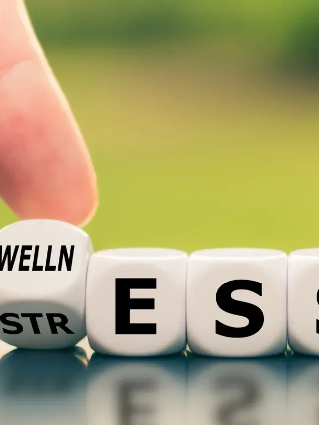 Wellness instead of stress. Hand turns a dice and changes the word "stress" to "wellness".