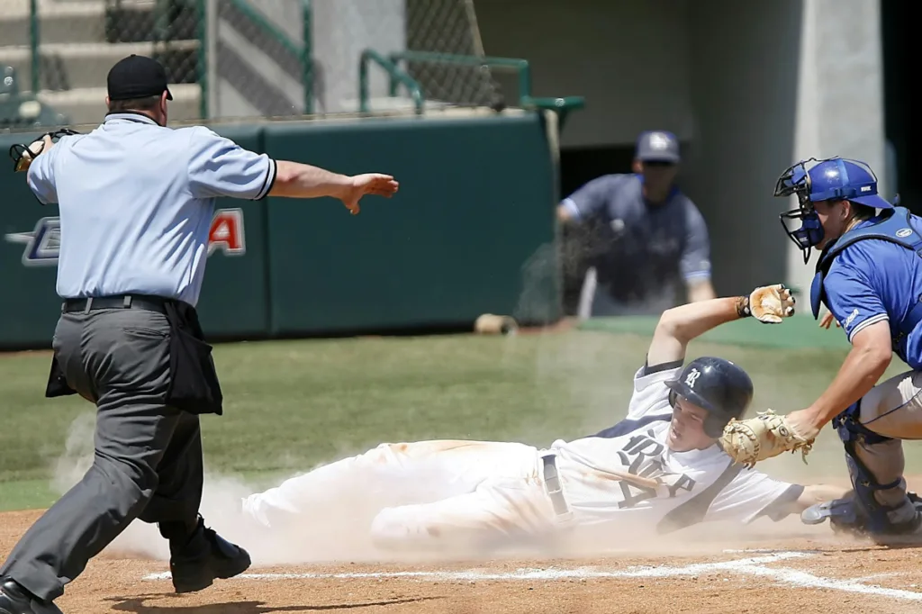 one player sliding to reach the halt and referee running towards him in a Baseball