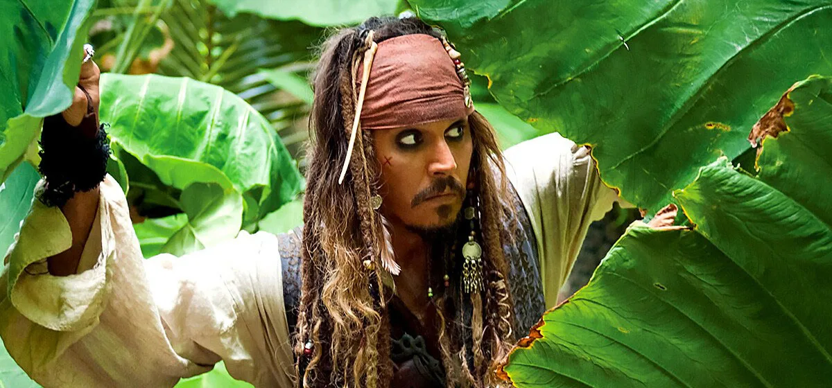 Captain Jack Sparrow peeking through leaves in a forest