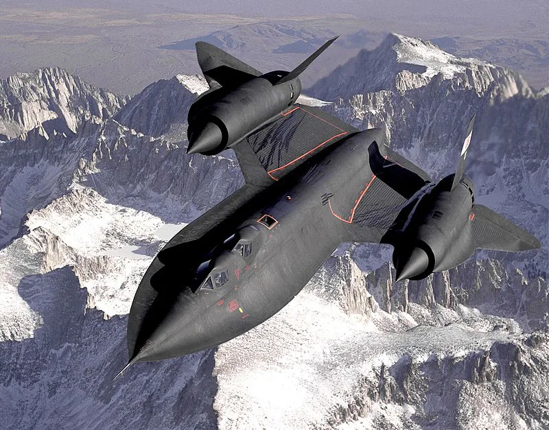 Two seater Lockheed SR-71 Blackbird flying above mountains