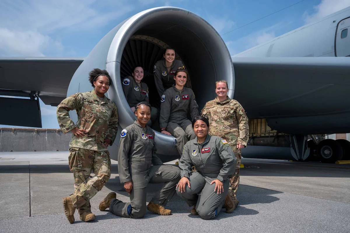 Group of women pilots sitting in and around the plane engine Women in United States Military Aviation