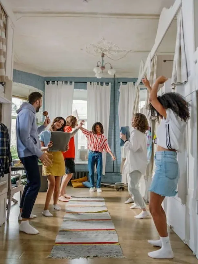 group of men and women inside a room dancing and enjoying