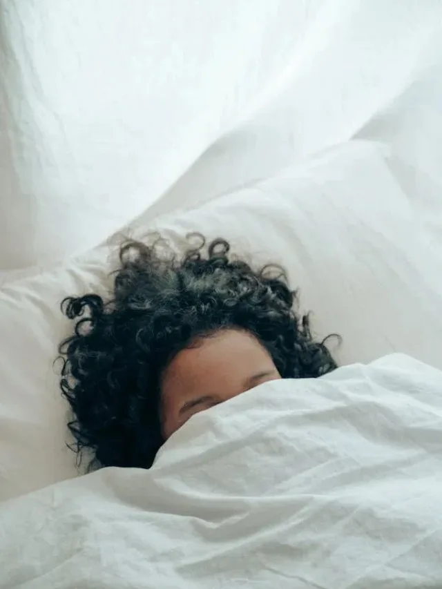 curly hair girl sleeping with face covered below eyebrows background white