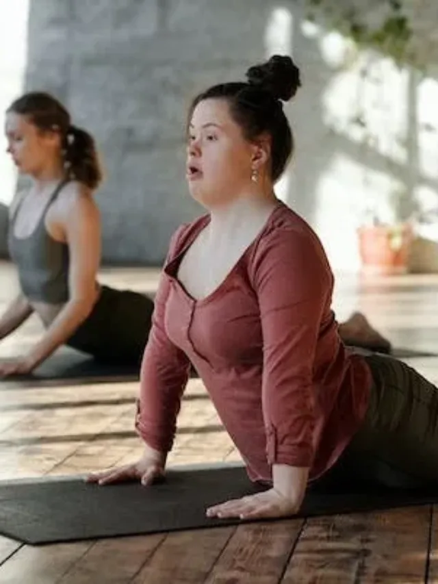 One woman in background and fat woman in foreground doing bhujangasana