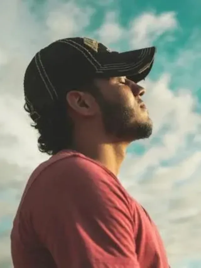 Man with a cap in orange t shirt looking at the sky mindfulness