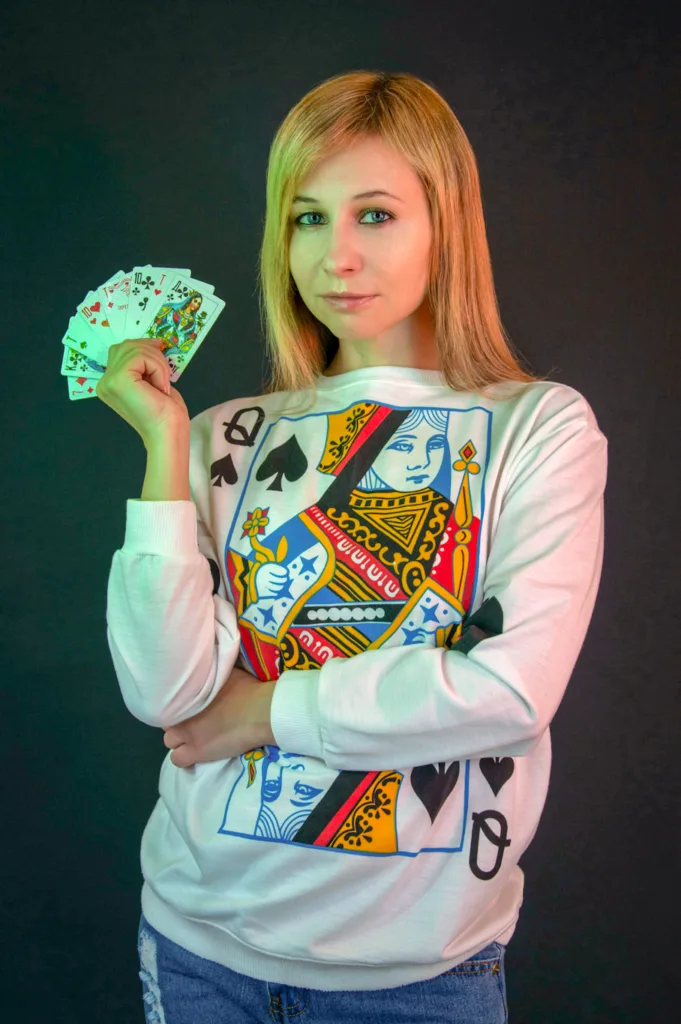 photo-of-a-woman-in-a-white-sweater-holding-playing-cards