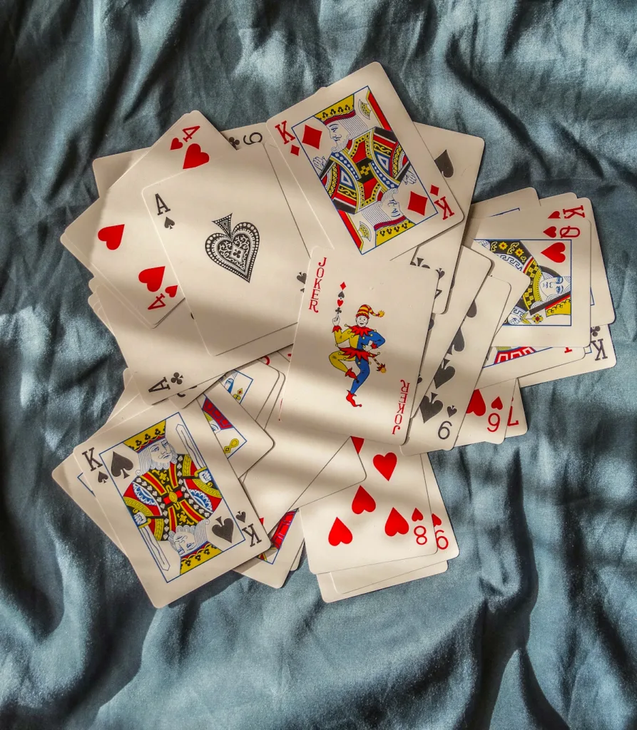 playing cards spread on a blue cloth History of Casino Chips