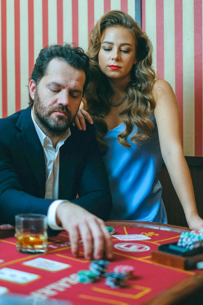 Woman in blue dress placing hand on a man who is playing on a casino table -Mind of a Professional Gambler