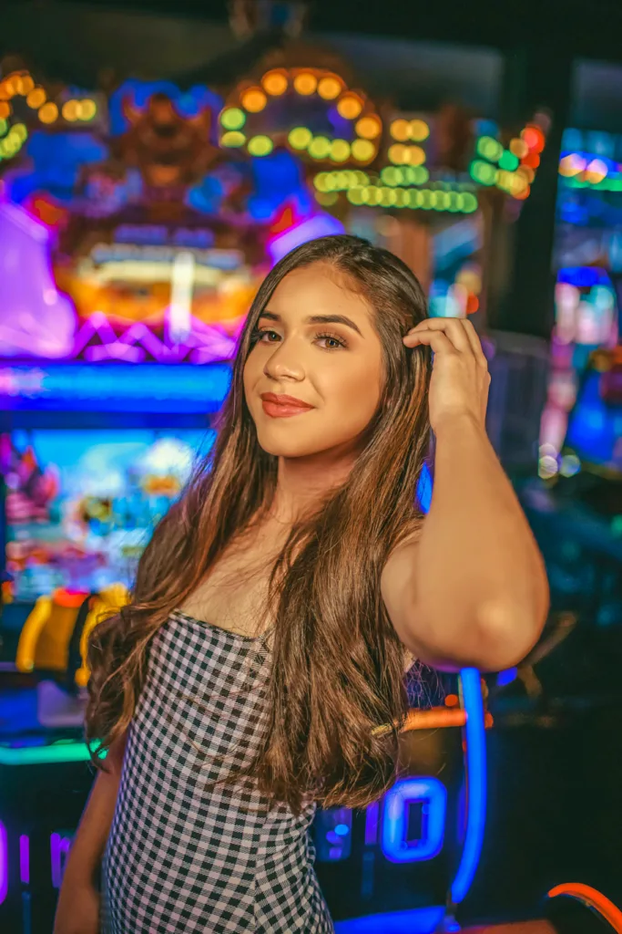 woman in checks curling her hair and smiling inside a casino