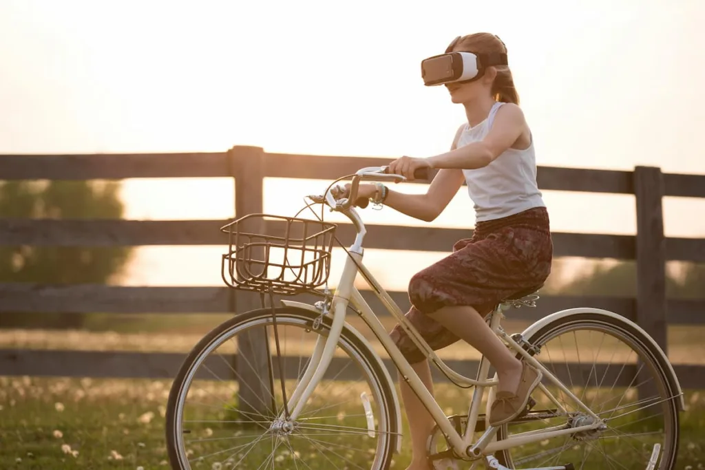 Girl with VR headset cycling in open