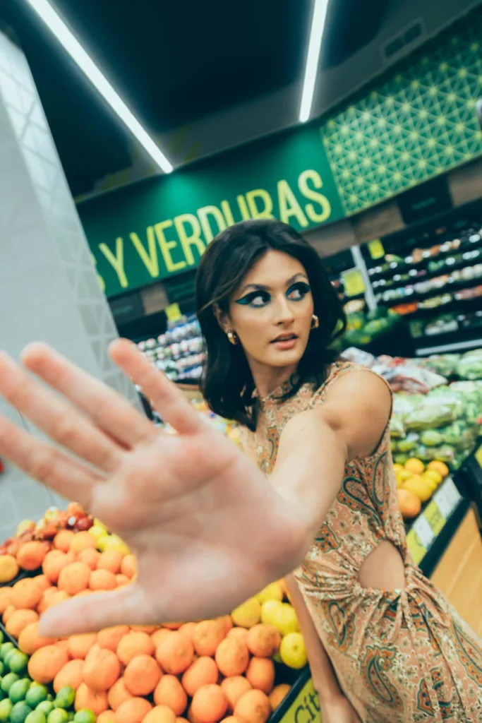 woman inside a grocery store stopping sign with left hand