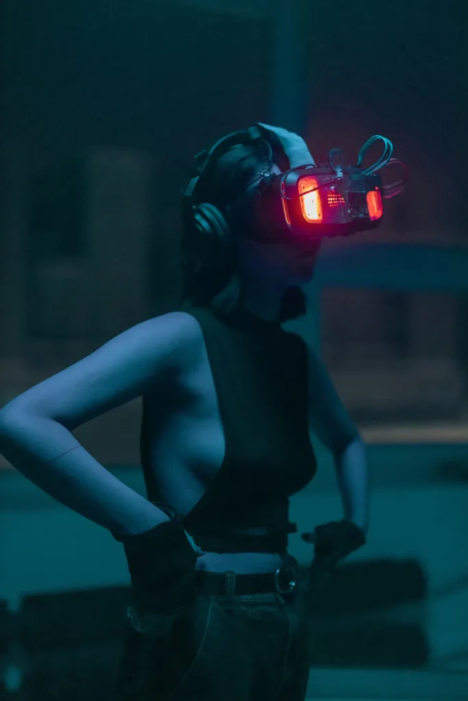 Woman in dark top with VR headset standing in a dark environment