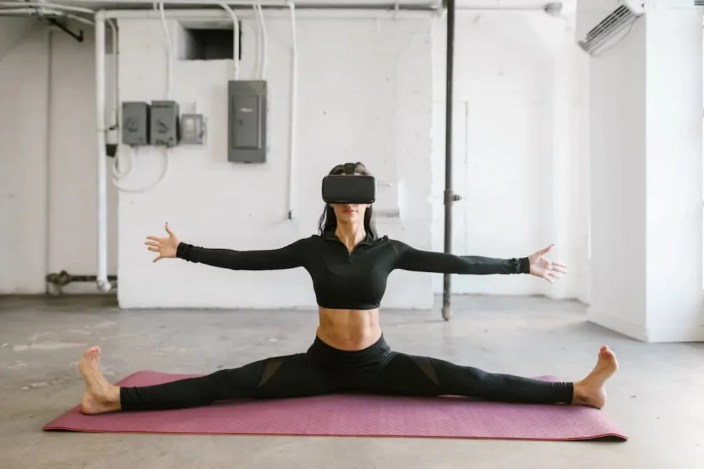 A woman in black yoga pants and long sleeves top wearing VR box and practicing yoga