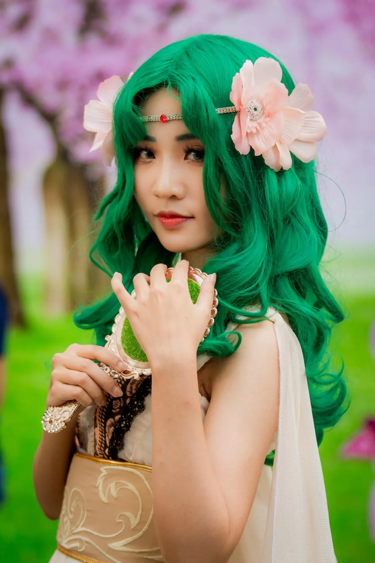 A beautiful girl just like in comics with green hair holding a small mirror