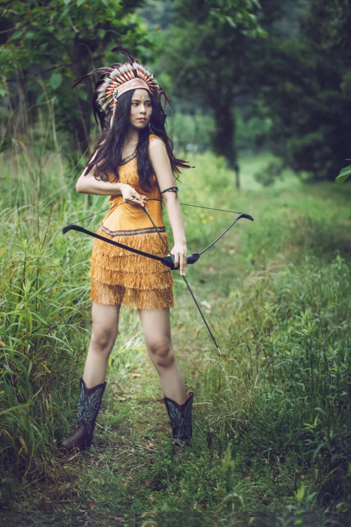 A woman with bow and arrow in orange red Indian attire Secrets of Comic-Con