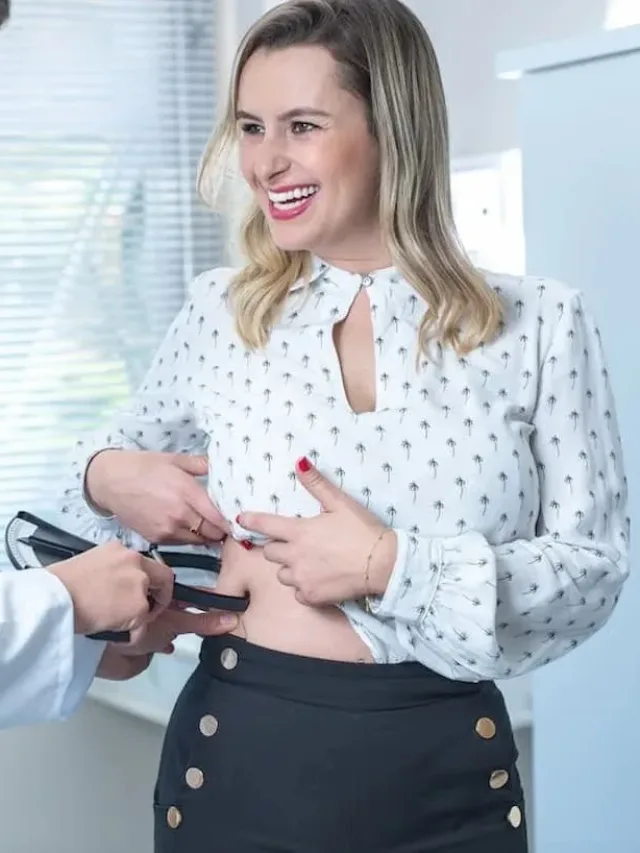 A woman getting her fat analyzed by a doctor