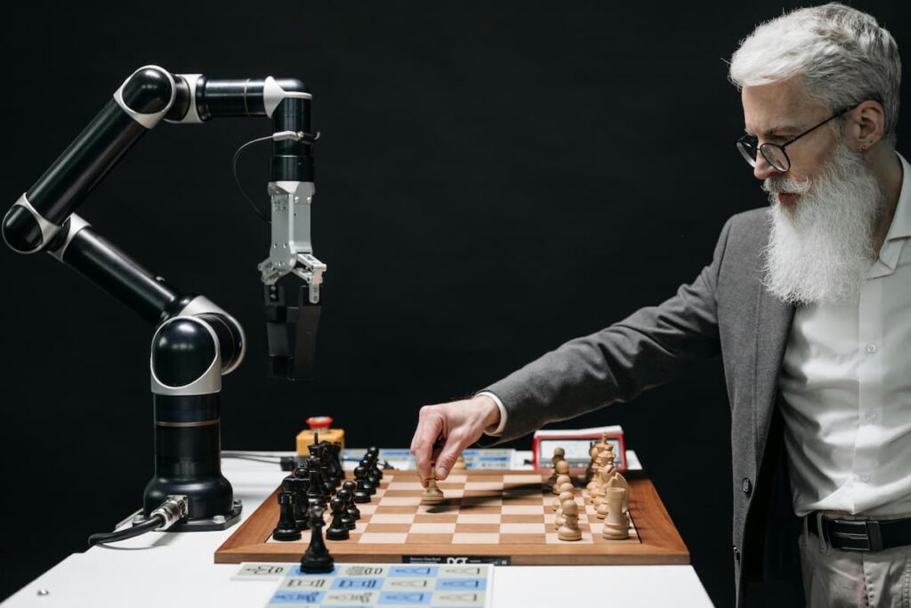 A man in beard playing chess with a robot